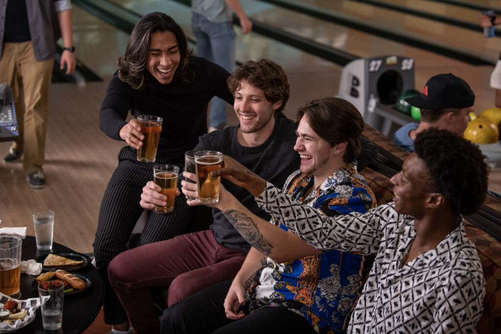 Friends enjoying food and drinks while bowling